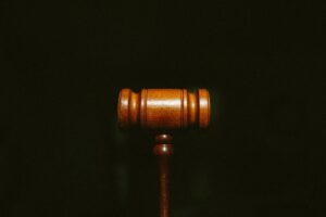 Wrongful Death Claim Lawyer New Orleans, LA A wooden gavel centered on a dark background with grain.