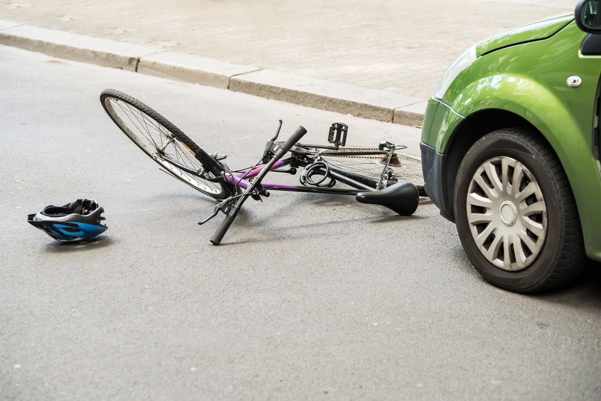 Injured cyclist beside road after vehicle impact