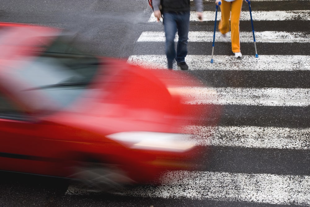 Injured pedestrian lying beside crosswalk after accident